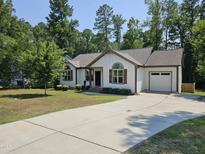 Charming one-story home featuring neutral siding, an attached garage, and a well-maintained front yard at 1212 E Middleton Dr, Creedmoor, NC 27522
