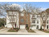 Brick townhouse showcasing a one-car garage and well-maintained landscaping with mature trees at 3118 Settle In Ln, Raleigh, NC 27614