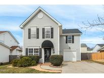 Charming two-story home with gray siding, black shutters, awning, and a well-manicured front yard at 404 Sunland Dr, Mebane, NC 27302