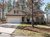 Charming one-story home featuring a 2-car garage, brick accents, and lush front lawn at 504 Forrest Dr, Sanford, NC 27330