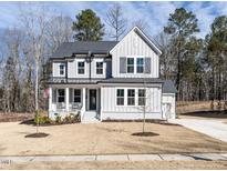 Charming two-story home with a welcoming front porch and a well-maintained, spacious front yard at 696 The Parks Dr, Pittsboro, NC 27312