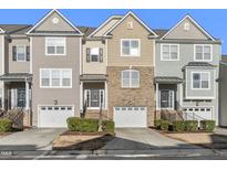 Charming townhome featuring varied siding and brick accents, with a one-car garage and tidy landscaping at 711 Keystone Park Dr # 51, Morrisville, NC 27560