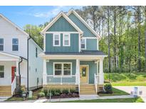 Charming two-story home featuring blue siding, a welcoming front porch, and manicured landscaping at 120 Weavers Grove Dr, Chapel Hill, NC 27514