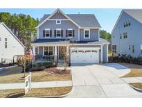 Charming two-story home with gray siding, a front porch, manicured lawn, and a two-car garage at 127 Hidden Bluff Drive, Chapel Hill, NC 27517