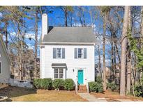 Charming two-story home featuring a light exterior, teal door, manicured landscaping, and a welcoming entrance at 322 Wax Myrtle Ct, Cary, NC 27513