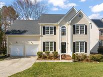 Charming two-story home featuring a two-car garage, manicured lawn, and traditional architectural details at 3515 Meadowrun Dr, Durham, NC 27707