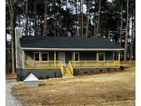 Charming home featuring a spacious front porch, painted a grey tone with yellow railings at 3588 Northern Hills Dr, Rocky Mount, NC 27804
