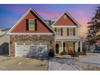 Inviting two-story home featuring a stone facade and an attached two-car garage at 4204 Vineyard Ridge Dr, Zebulon, NC 27597