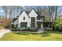 Beautiful modern home features black trim windows, white painted brick and professionally landscaped yard at 4208 Windsor Pl, Raleigh, NC 27609