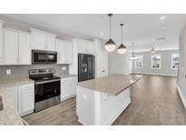 Open kitchen featuring stainless steel appliances, granite countertops, and a large island at 507 Gateway Townes Blvd, Wake Forest, NC 27587