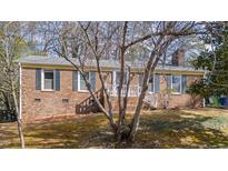 Charming brick home featuring green shutters and a welcoming front porch at 6404 Dixon Dr, Raleigh, NC 27609
