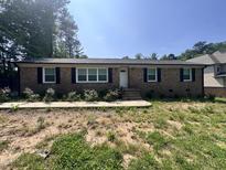 Charming single-story brick home with well-maintained landscaping and symmetrical design at 7103 Big Horn Dr, Hillsborough, NC 27278