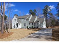 Charming two-story home with white and light green siding, a grey roof, and a well-manicured lawn at 7112 Camp Side Ct, Raleigh, NC 27613