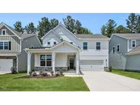 Charming two-story home with a welcoming front porch and well-manicured lawn at 7521 Percussion Dr, Apex, NC 27539