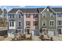 Charming townhomes featuring varied siding colors, attached garages, and well-maintained landscaping at 905 Arnold Place Dr, Fuquay Varina, NC 27526