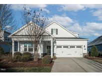 Charming two-story home featuring a welcoming front porch and a two-car garage with neutral paint at 1129 Aberlour Ln, Burlington, NC 27215