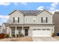 Lovely two-story home featuring solar panels, a two-car garage, and a cozy front porch at 1610 Stone Rd, Durham, NC 27703
