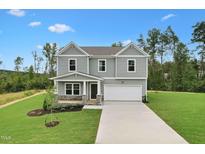 Two story home with neutral siding, a two car garage, a covered front porch and professionally landscaped yard at 181 Cribbs Ln, Middlesex, NC 27557