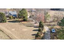 Beautiful front yard featuring a long driveway and mature trees surrounding a blue home at 2490 Earpsboro Rd, Zebulon, NC 27597