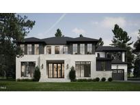 Stunning modern home with a light brick and stone exterior, black trim windows, lush lawn, and professional landscaping at 4308 Windsor Pl, Raleigh, NC 27609