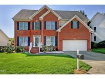 Traditional two-story brick home featuring a well-manicured lawn and attached two car garage at 5008 Casland Dr, Raleigh, NC 27604
