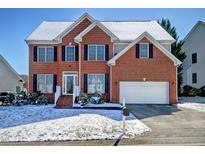 Traditional two-story brick home with a two-car garage and a snow-covered front yard at 5008 Casland Dr, Raleigh, NC 27604