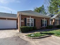Charming brick home featuring black shutters, manicured landscaping, and attached garage at 1013 Thistle Briar Pl, Cary, NC 27511