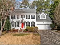 Charming two-story home featuring a red front door, white siding, and manicured landscaping at 104 Somersby Ct, Cary, NC 27519
