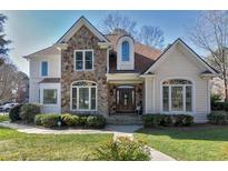Charming two-story home features a stone facade, arched windows and well-manicured landscaping at 116 Old Pros Way, Cary, NC 27513