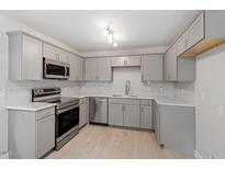 Bright kitchen features stainless steel appliances, gray cabinets, stone countertops, and subway tile backsplash at 1213 Freeman Dr, Sanford, NC 27330