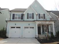 Charming light blue two-story home with a two-car garage and dark shutters at 1872 Stagecoach Trl, Wendell, NC 27591