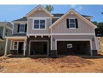 New two-story home with attached two-car garage, and a combination of gray siding and stone facade at 235 Augusta Pond Way # 161, Raleigh, NC 27603