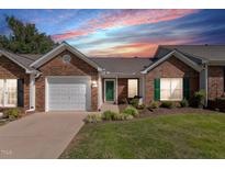 Charming brick home with a one-car garage, manicured lawn, and inviting green door at 3027 Maple Ave # D2, Burlington, NC 27215
