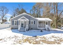 Charming home features a screened porch and a cozy front entrance with steps, surrounded by a snow-covered yard at 325 West 3Rd St, Wendell, NC 27591