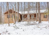 Charming brick home featuring a covered porch and wintery wooded surroundings at 3412 Hackney Ct, Raleigh, NC 27613