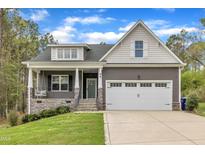 Charming home featuring a welcoming front porch with swing and a two-car garage at 96 Linda Lou Ln, Angier, NC 27501