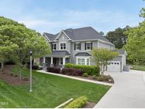 Stunning two-story home featuring a well-manicured lawn, complemented by an attached two-car garage and a tree-lined front yard at 1005 Keith Rd, Wake Forest, NC 27587