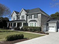 Traditional two-story home featuring gray brick, black shutters, gabled roof and well-manicured lawn at 1005 Keith Rd, Wake Forest, NC 27587