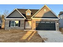 Charming brick home with a two-car garage and landscaped front yard at 1063 Fairhaven Dr # 54, Mebane, NC 27302