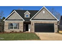 Charming brick home with a black garage door, gray shingle accents, and a well-manicured lawn at 1063 Fairhaven Dr # 54, Mebane, NC 27302
