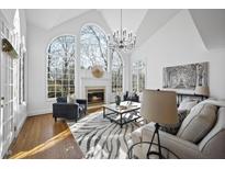 Bright living room featuring large arched windows, fireplace, and modern lighting at 11000 Holkham Ct, Raleigh, NC 27614