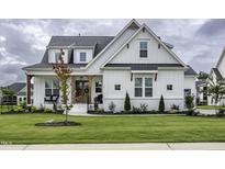 Beautiful white farmhouse-style exterior with a manicured lawn and welcoming front porch at 113 Nate Court Ct, Wake Forest, NC 27587