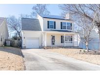 Charming two-story home featuring a front porch, attached garage, and well-maintained landscaping at 117 Crabwall Ct, Holly Springs, NC 27540