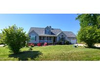 Charming home with a well-manicured lawn, flowering bushes, and a welcoming front porch, perfect for relaxing at 1317 Justin Oaks Ct, Willow Springs, NC 27592