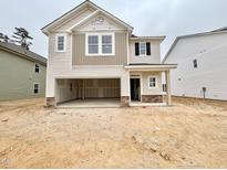 New two-story home featuring an attached two-car garage and stone accents in a developing neighborhood at 142 Muskogee Rd # 57, Angier, NC 27501