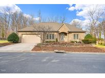 Charming brick home featuring a well-maintained yard, attached two-car garage, and inviting front entrance at 2309 Grey Gables W Dr, Burlington, NC 27215