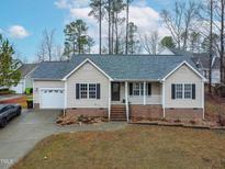 Charming single-story home featuring a brick foundation, well-kept lawn and an attached garage at 2576 Mint Julep Dr, Creedmoor, NC 27522