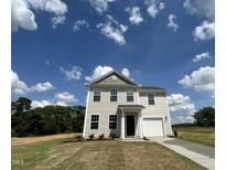Charming two-story home featuring vinyl siding, an attached garage, and a well-manicured lawn at 260 Johnson Ridge Way, Four Oaks, NC 27524