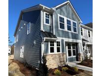 Two-story home with light-blue siding, multiple windows, and a stone facade for a charming, modern look at 334 Church St # 46, Wendell, NC 27591