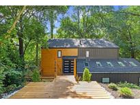 Unique exterior view of home with wood and dark siding, natural landscaping, and a wood deck entry at 3506 Bellevue Rd, Raleigh, NC 27609